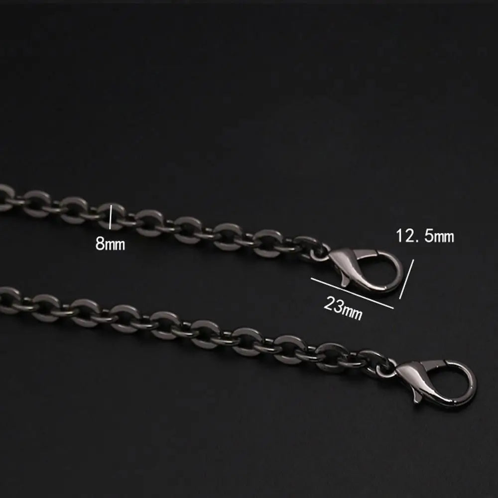A close-up of a black metal chain strap with adjustable links and a clasp, shown against a dark background.