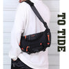 Eine Person trägt eine schwarze taktische Brusttasche mit orangefarbener Akzent auf einem weißen Langarmshirt.