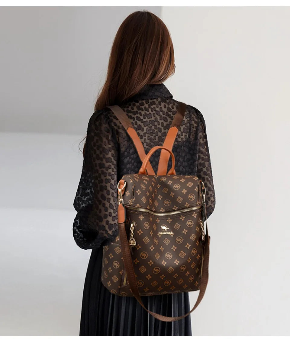 A woman is shown from the back wearing a brown genuine leather backpack with a leopard print shirt and a black skirt.