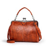 A brown leather crossbody shoulder bag with a silver-toned chain strap and decorative metal hardware.