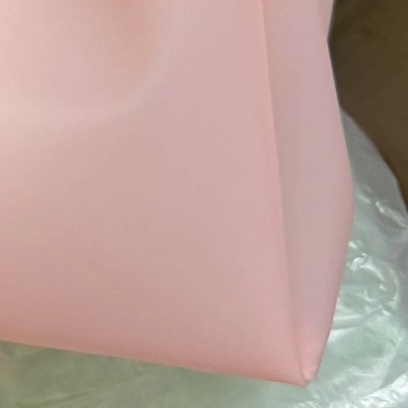 Gros plan d'un sac fourre-tout en gelée transparente rose pâle Y2K.