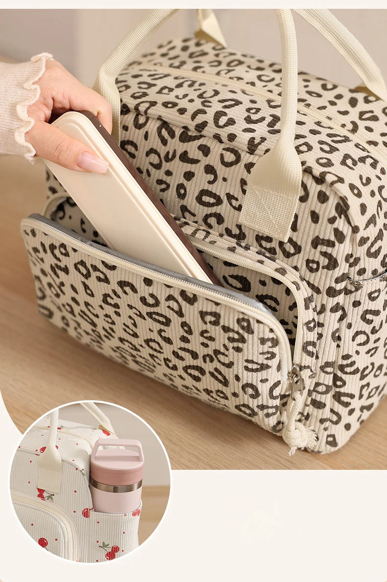 A leopard print insulated lunch bag is shown open with a light-colored tablet or notebook inside.