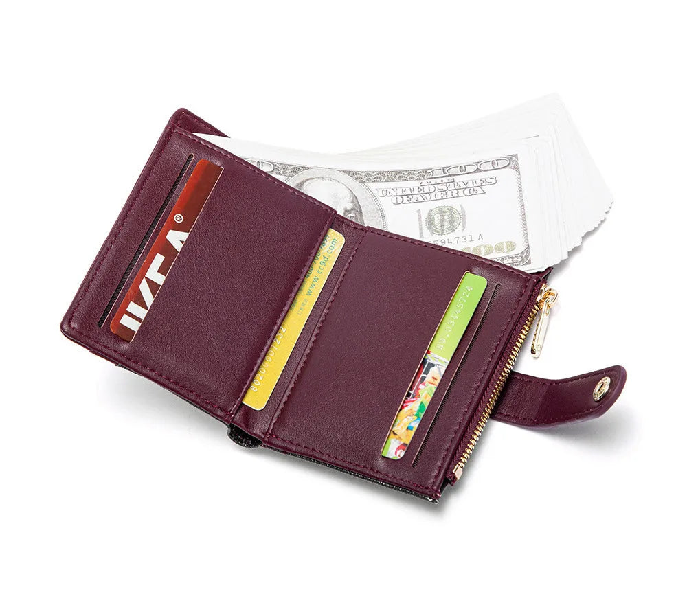 A maroon folding wallet with a gold accent holds cash and cards against a white background.