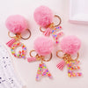 Pink fuzzy pom-pom initial letter keychain charms in shiny resin for bags and backpacks