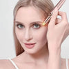 A woman is using a precision electric eyebrow trimmer with an LED light to shape her eyebrows.
