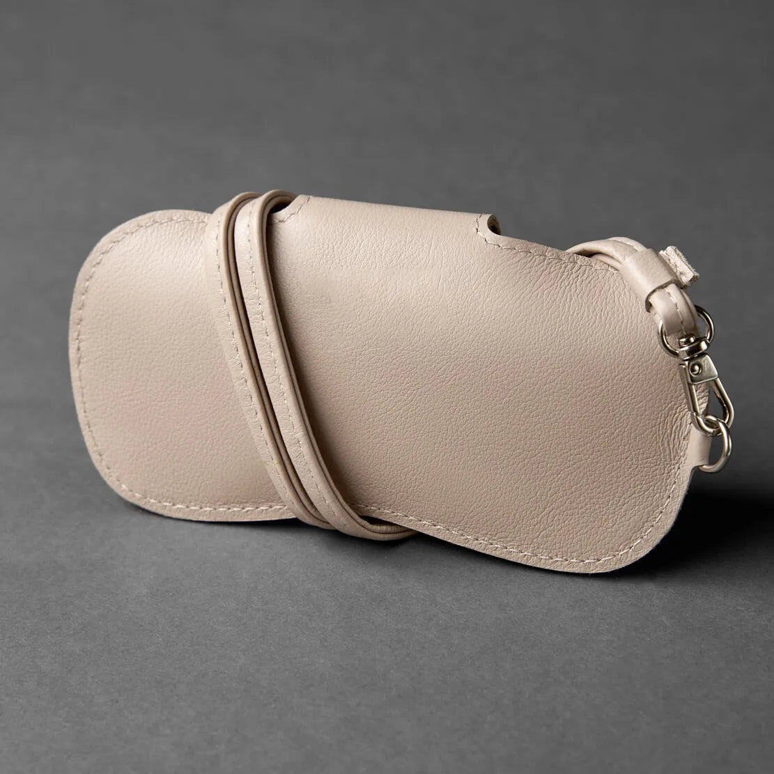A light beige PU leather storage case for eyewear, shown in a profile view.