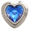 A heart-shaped silver metal fold-over bag hook featuring a large blue gemstone.