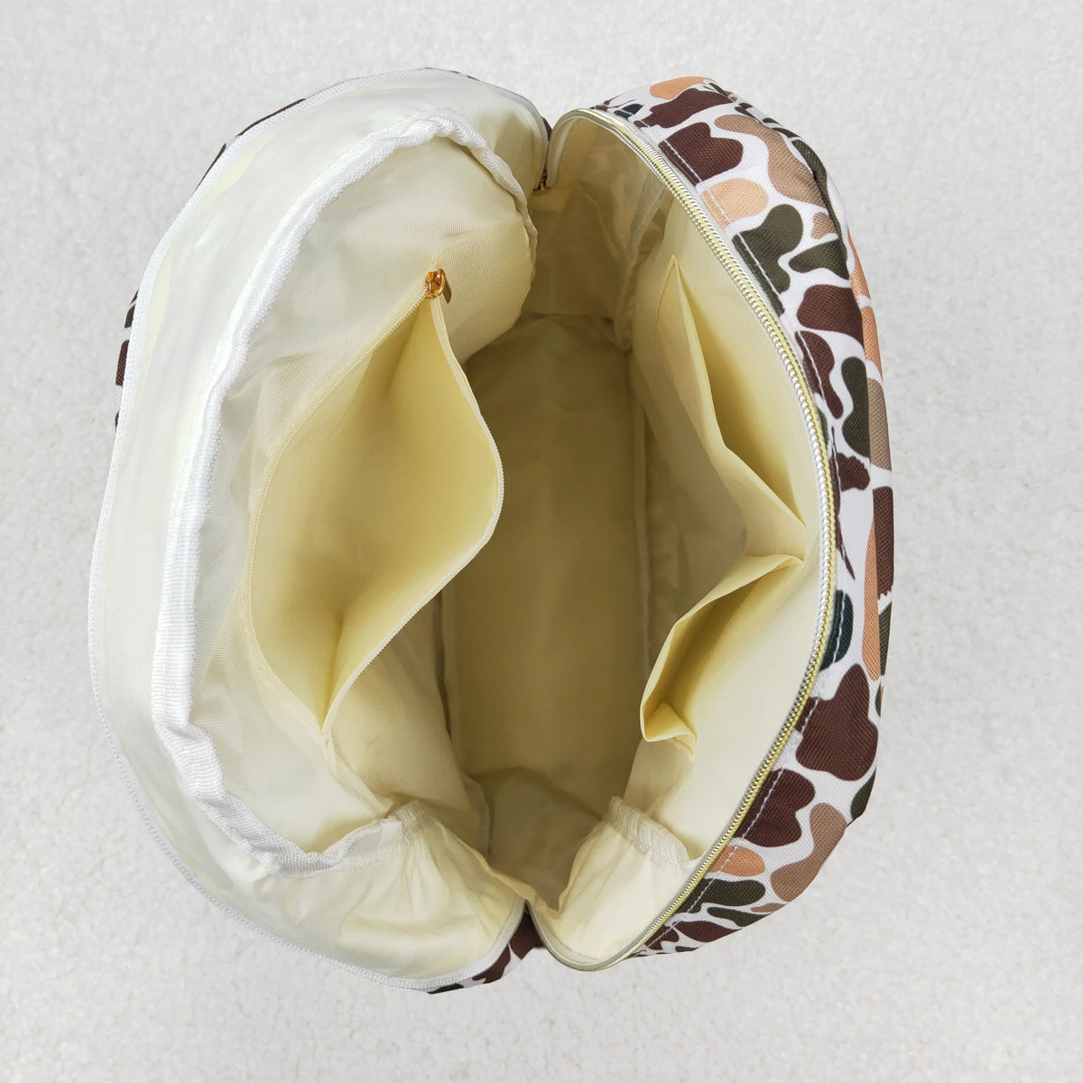 A light beige toddler backpack featuring a brown and white animal print pattern.