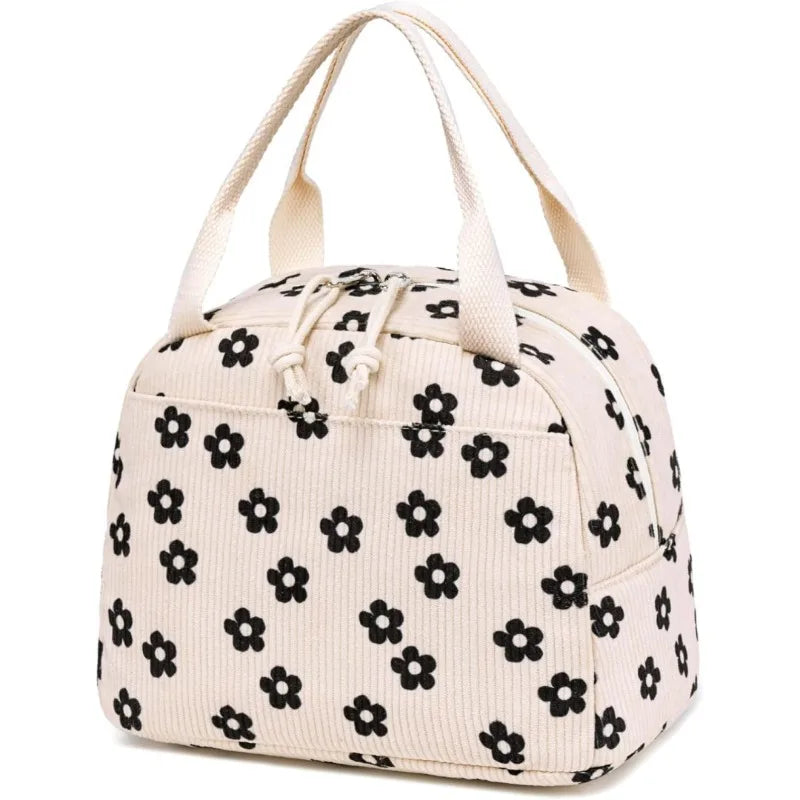 A beige corduroy lunch bag for kids with light yellow stitching and fabric flowers.