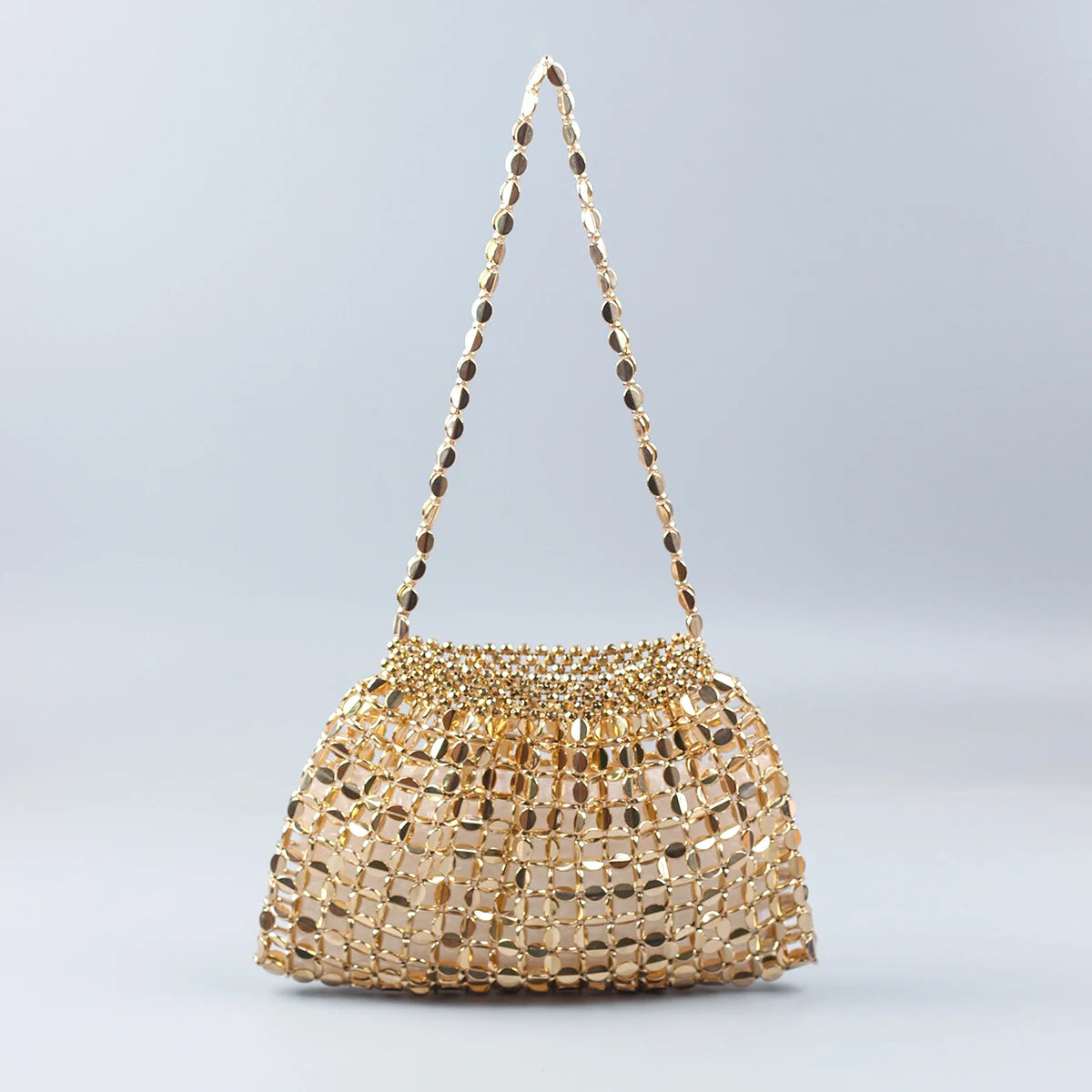 A handmade dumpling bag covered in gold and silver beads, displayed against a light gray background.