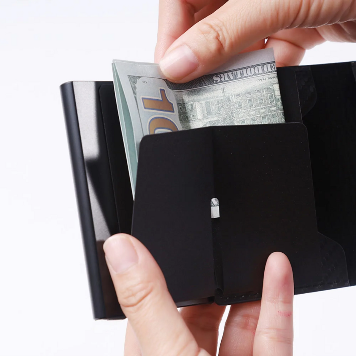 Hands are inserting a ten dollar bill into a black minimalist RFID blocking wallet.