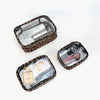 A leopard print clear cosmetic bag with a lid, holding various beauty products like bottles and containers.