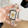 Eine Hand hält ein Edelstahlarmband einer Uhr mit quadratischem Zifferblatt und goldfarbenem Herzsymbol.