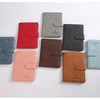Une collection de porte-passeport en cuir imperméable dans diverses couleurs, dont rouge, gris, noir et camel.