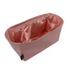 A pink luxury bag organizer insert featuring a silk lining and a zippered compartment.