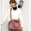 A woman wearing a white shirt and jeans holds a pink canvas tote bag with brown leather straps.