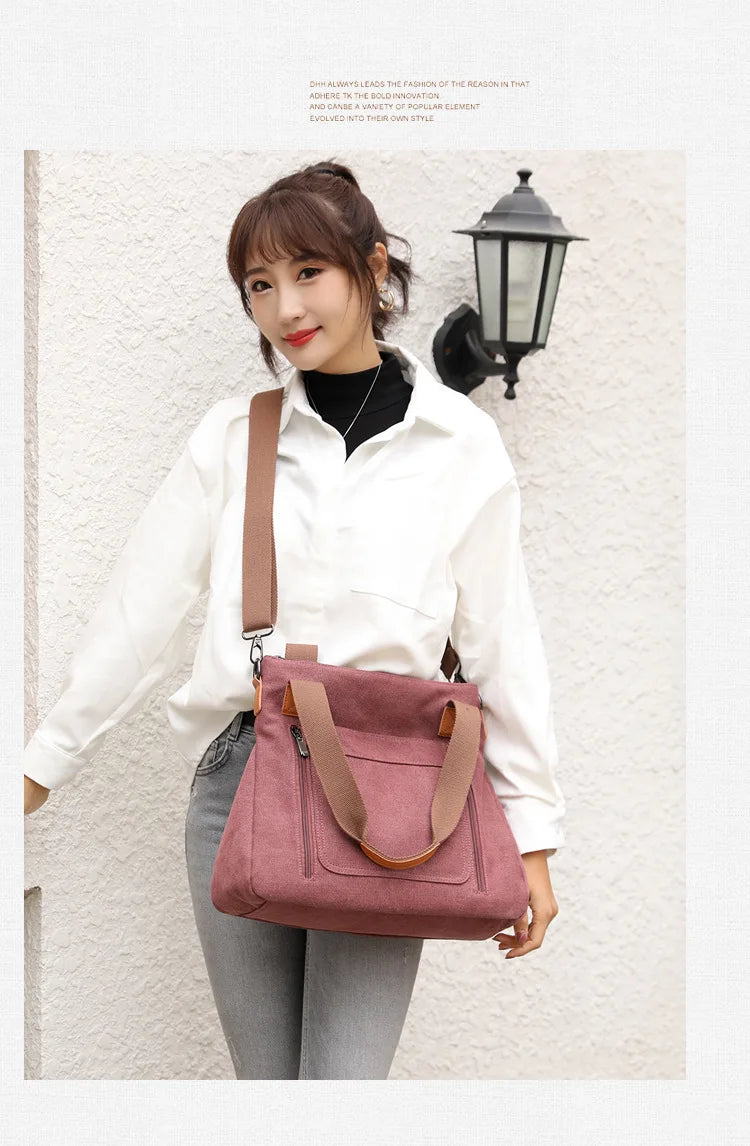 A woman wearing a white shirt and jeans holds a pink canvas tote bag with brown leather straps.