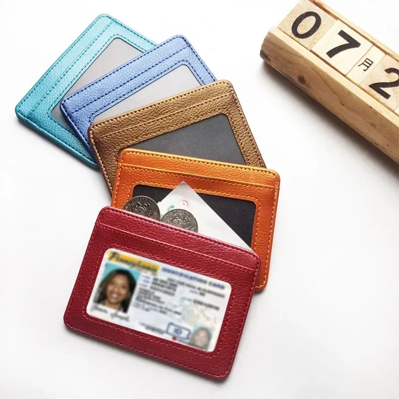 A stack of five slim PU leather mini wallets in various pastel and earth tones, including pink, blue, beige, and orange.