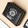Black fashion PU leather double zipper wallet with gold stitching on a beige background.