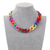 A colorful acrylic statement choker necklace displayed on a gray mannequin neck.