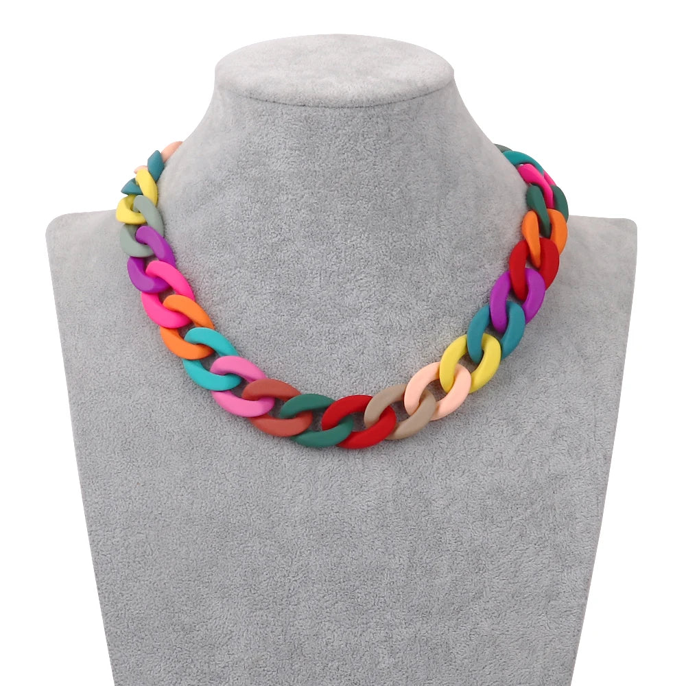 A colorful acrylic statement choker necklace displayed on a gray mannequin neck.