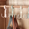A wooden clothing rack with multiple multi-functional hanging hooks in pink, gray, and beige colors.