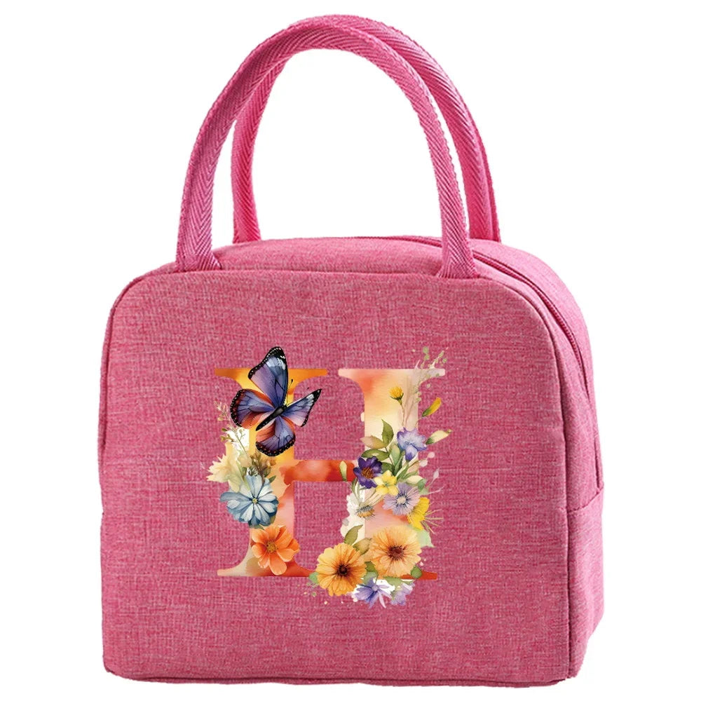 A pink insulated canvas lunch bag with a floral design and pink fabric handles.