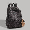 A dark gray leopard print backpack with black straps and a small teddy bear charm.