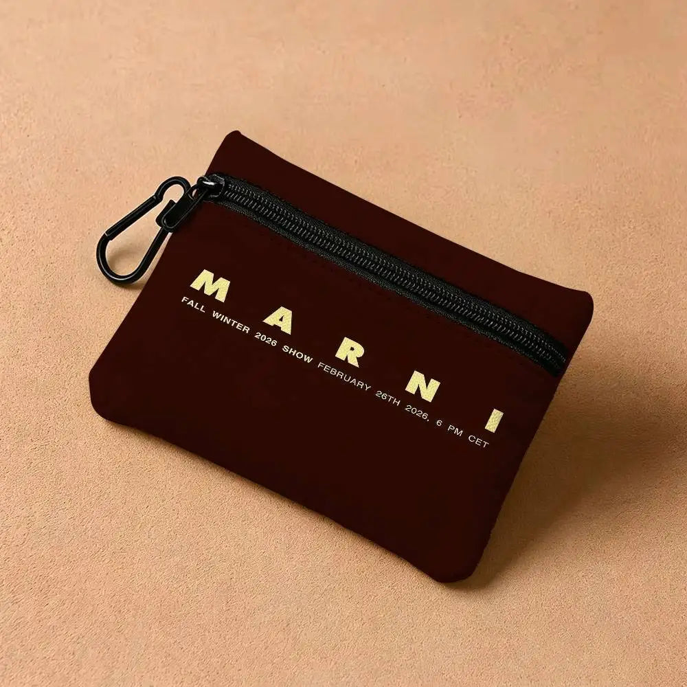 A dark maroon zippered pouch with gold lettering for a fashion show event.