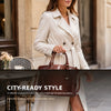Eine Frau trägt einen beige Trenchcoat und hält eine elegante Krokodilmuster-Top-Crossbodytasche.