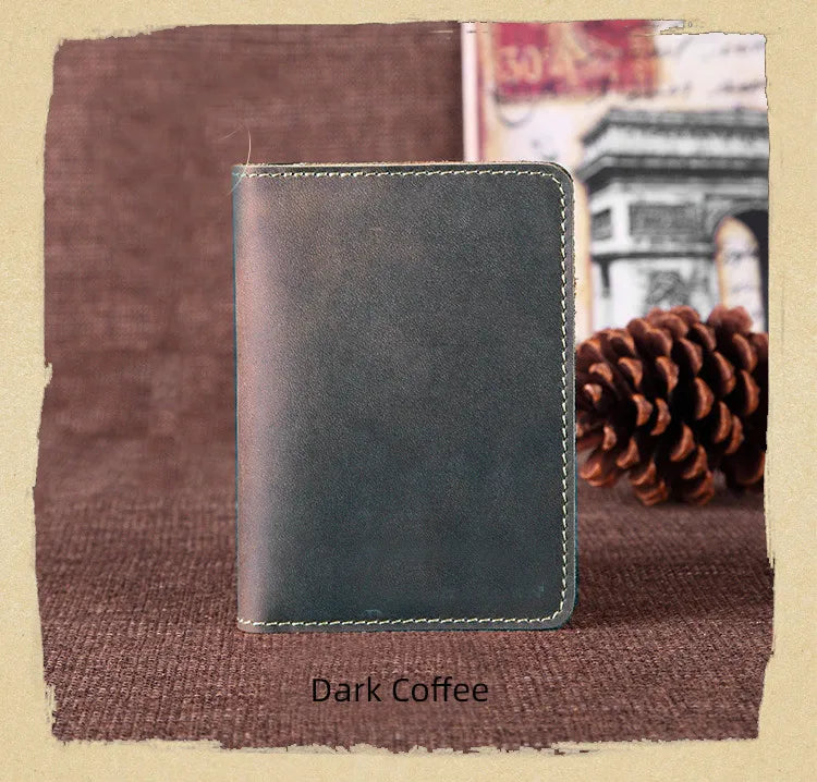 A dark coffee colored genuine leather passport wallet with card holders resting on a brown fabric.