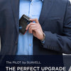 A man wearing a navy suit jacket and light blue shirt holds a black RFID blocking wallet.