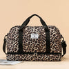A brown and black leopard print travel duffel bag with a zippered compartment and black straps.