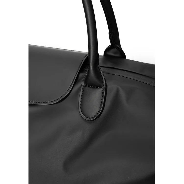 A black durable nylon travel duffle bag with a leather handle is shown from the top.