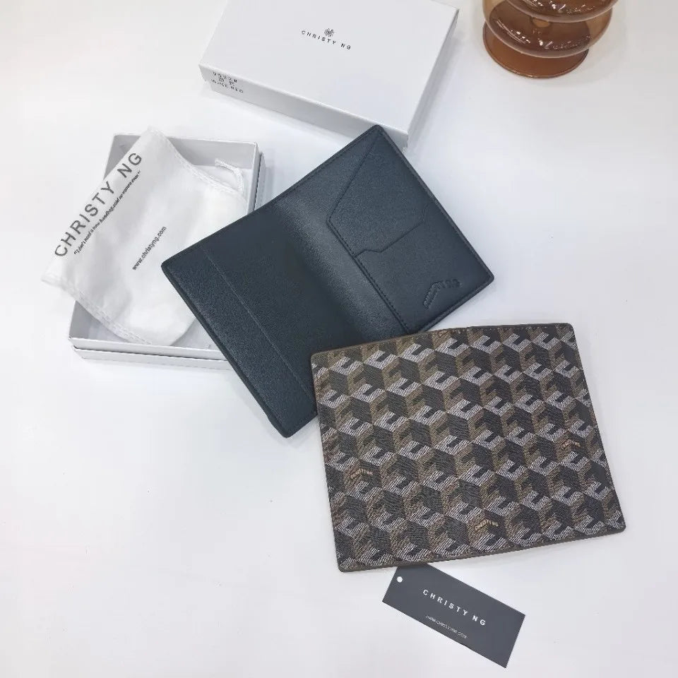 A dark gray geometric print passport wallet and a white tissue are displayed on a white surface.