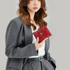 A woman models a red multi-fold RFID protection wallet and a gray coat.