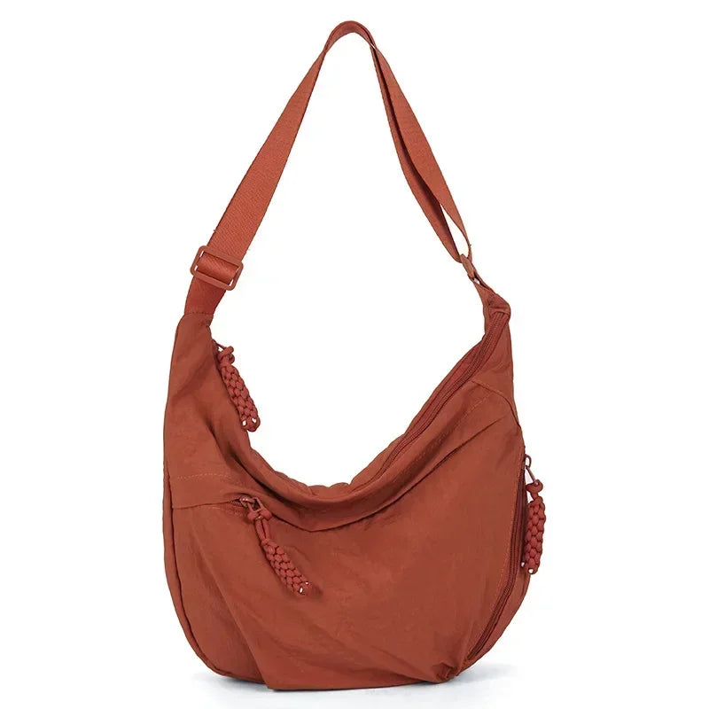A brown soft nylon crossbody shoulder bag with an adjustable strap.