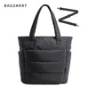 Sac cabas matelassé noir avec une sangle en forme de Z noire, sur fond blanc.