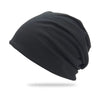 A black slouchy knit beanie hat shown from the side.