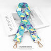 A colorful patterned nylon bag strap featuring blue, yellow, and green floral designs.