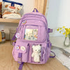 A purple Korean style backpack with a padded laptop compartment and cute animal charms