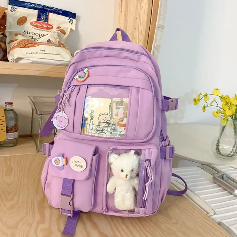A purple Korean style backpack with a padded laptop compartment and cute animal charms
