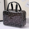 A clear waterproof makeup organizer bag with a black and white star pattern sits on a white surface.