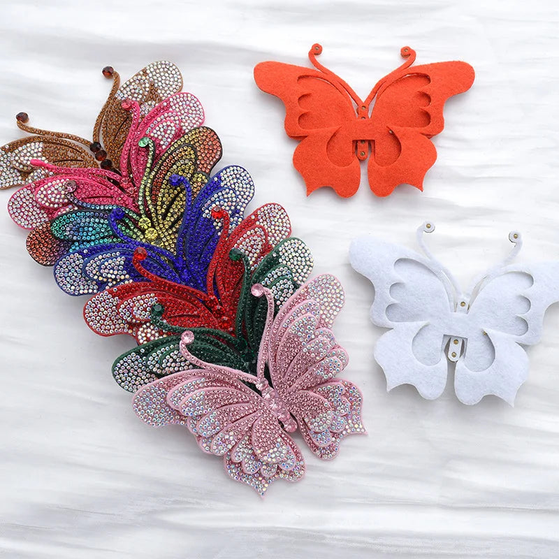 A collection of decorative rhinestone butterfly appliqués and stickers in various colors like orange, purple, green, and pink