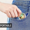 A hand is holding a small, oval-shaped bag hook with a bird design against a denim fabric.