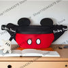 Una mochila de pato-ratón de peluche con orejas negras y cuerpo rojo, descansando sobre un libro abierto.