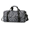 Maleta de viaje negra y blanca con estampado de leopardo y correas para hombros.