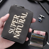 A dark gray compact card wallet with glowing text on the cover is held in a hand next to a separate black card holder.