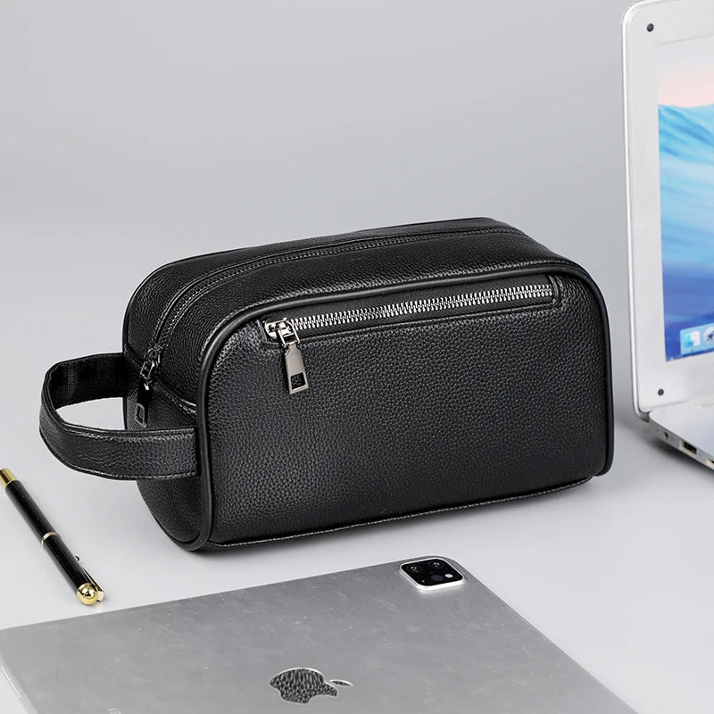 Pochette noire en cuir PU pour homme avec une sangle posée sur un ordinateur portable argenté.