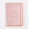 A pink leather passport holder with embossed eagle design and United States of America text.